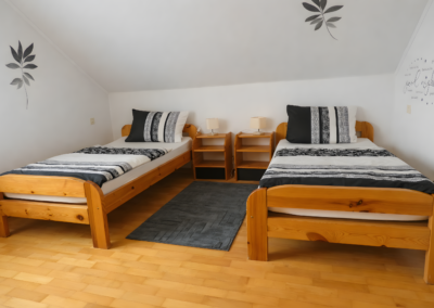 Gemütliches Schlafzimmer mit zwei Einzelbetten und moderner Wandgestaltung.
